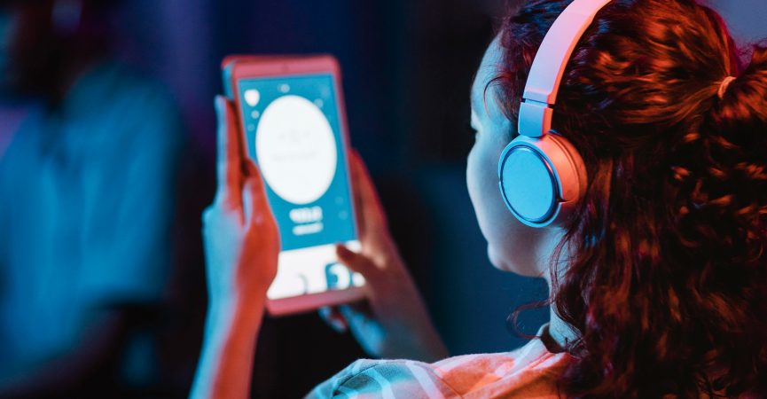 back-view-woman-home-using-headphones-tablet-1-e1740142752674.jpg