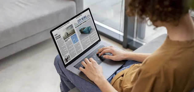 high-angle-man-reading-digital-magazine.webp
